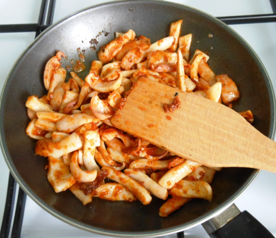И как только масло растаяло, а сковородка сильно нагрелась, всыпаем на неё соломку из кальмаров в панировке и жарим 1,5 - 2 минуты.